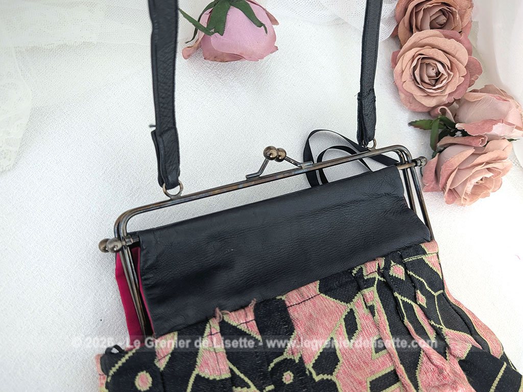 De la marque "Emma Blonde", voici un superbe sac minaudière vintage en tissu jacquard noir et rose très Art Déco, avec un haut en cuir noir et fermé par une armature en métal et doublé d'un satin fuchsia. A porterà l'épaule grâce à sa bandoulière en cuir noir ou à la main. Années 2000.