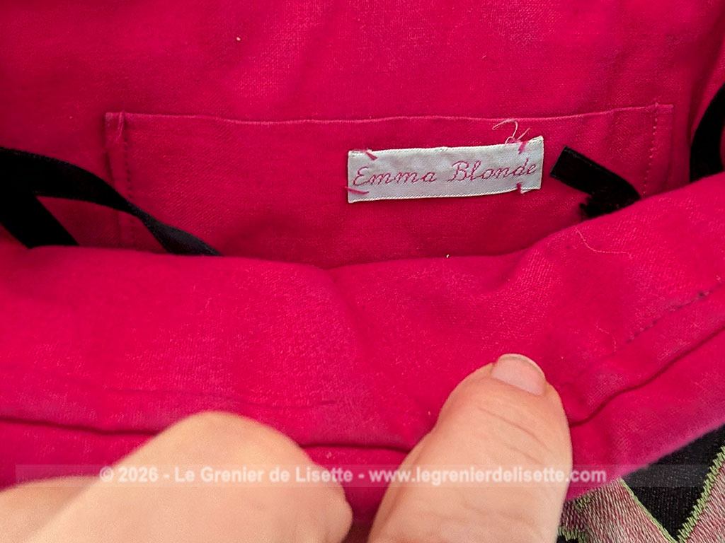 De la marque "Emma Blonde", voici un superbe sac minaudière vintage en tissu jacquard noir et rose très Art Déco, avec un haut en cuir noir et fermé par une armature en métal et doublé d'un satin fuchsia. A porterà l'épaule grâce à sa bandoulière en cuir noir ou à la main. Années 2000.