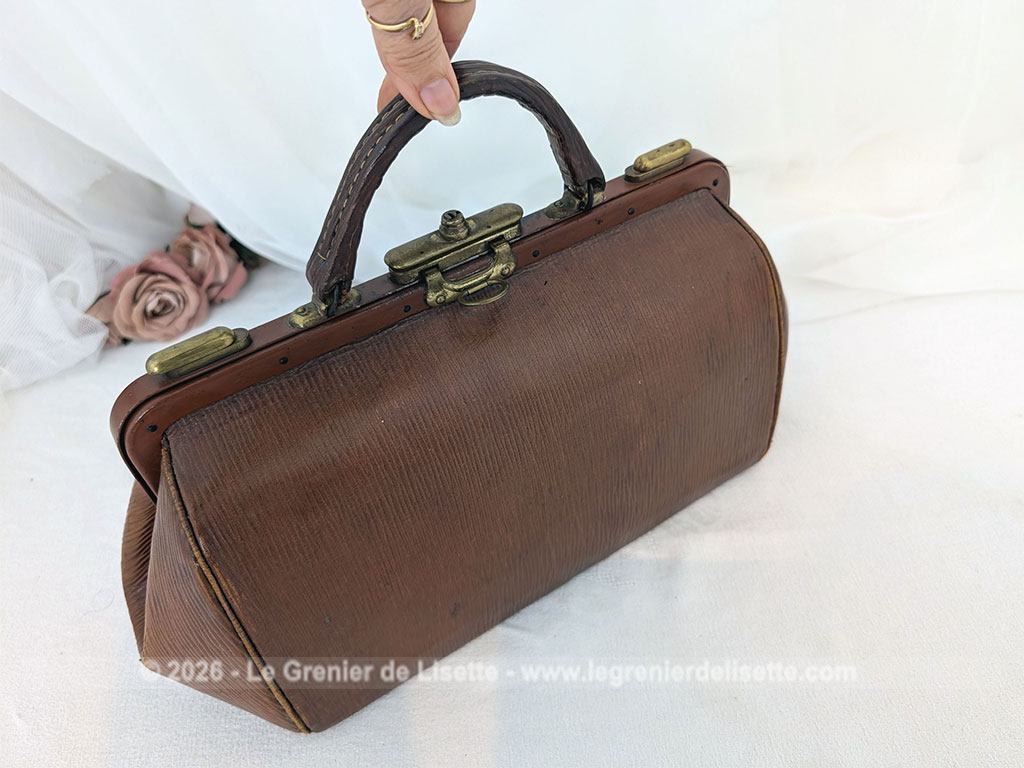 Voici un magnifique sac à main vintage des années 50/60 en cuir rigide de couleur fauve arborant la forme intemporelle d'une authentique sacoche de médecin avec une superbe patine. Top vintage .