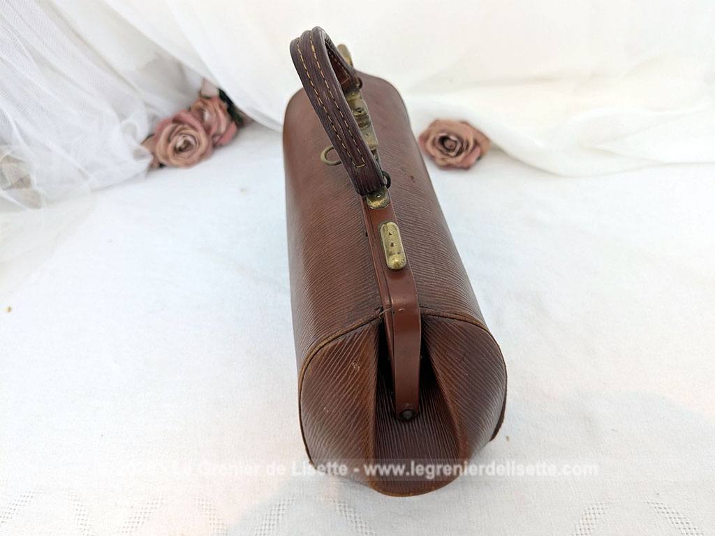 Voici un magnifique sac à main vintage des années 50/60 en cuir rigide de couleur fauve arborant la forme intemporelle d'une authentique sacoche de médecin avec une superbe patine. Top vintage .