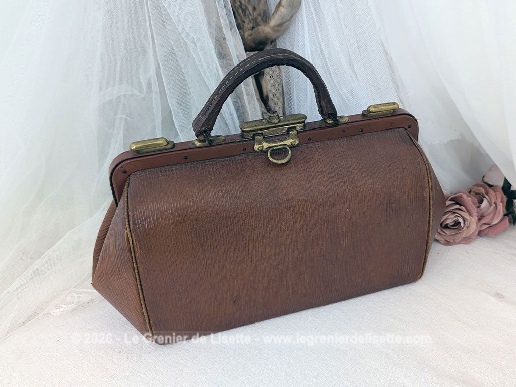 Voici un magnifique sac à main vintage des années 50/60 en cuir rigide de couleur fauve arborant la forme intemporelle d'une authentique sacoche de médecin avec une superbe patine. Top vintage .