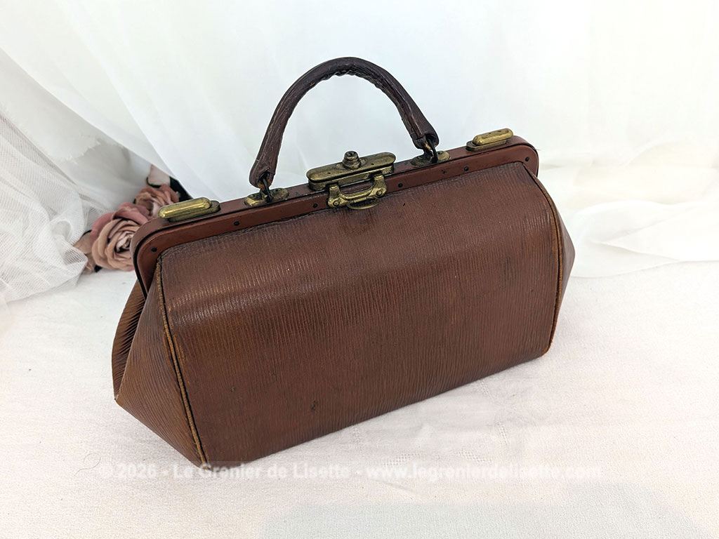 Voici un magnifique sac à main vintage des années 50/60 en cuir rigide de couleur fauve arborant la forme intemporelle d'une authentique sacoche de médecin avec une superbe patine. Top vintage .