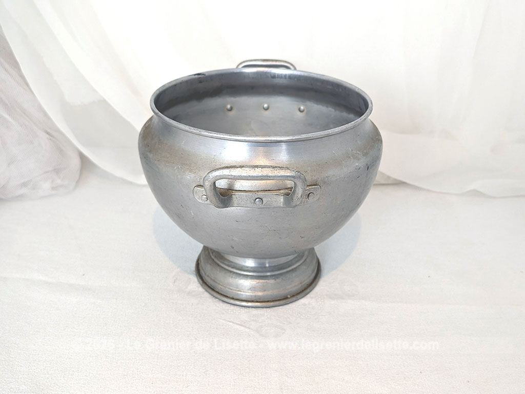 Voici un corps de soupière vintage en aluminium au charme rustique et authentique avec sa ligne ventrue qui repose sur un élégant piédouche et ses deux anses rivetées. Proposée sans son couvercle elle se transforme idéalement en un grand saladier, cache pot ou un centre de table de caractère.