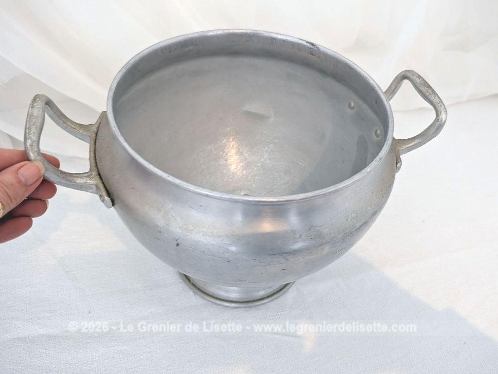 Voici un corps de soupière vintage en aluminium au charme rustique et authentique avec sa ligne ventrue qui repose sur un élégant piédouche et ses deux anses rivetées. Proposée sans son couvercle elle se transforme idéalement en un grand saladier, cache pot ou un centre de table de caractère.