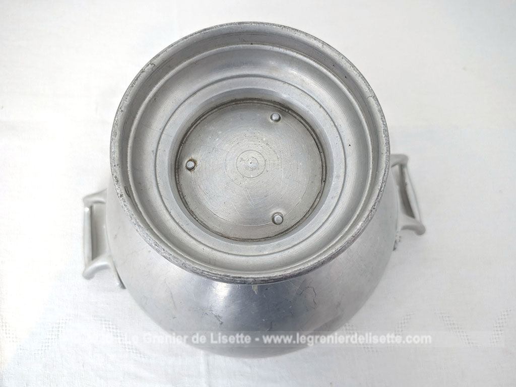 Voici un corps de soupière vintage en aluminium au charme rustique et authentique avec sa ligne ventrue qui repose sur un élégant piédouche et ses deux anses rivetées. Proposée sans son couvercle elle se transforme idéalement en un grand saladier, cache pot ou un centre de table de caractère.