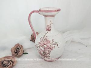 Sur 25 cm de haut, voici un joli vase pichet en terre cuite émaillée blanche décoré d'un superbe décor floral peint à la main dans de beaux tons rose poudré, souligné de fins contours brun clair tracés à la main. Signé et Made in Italy.