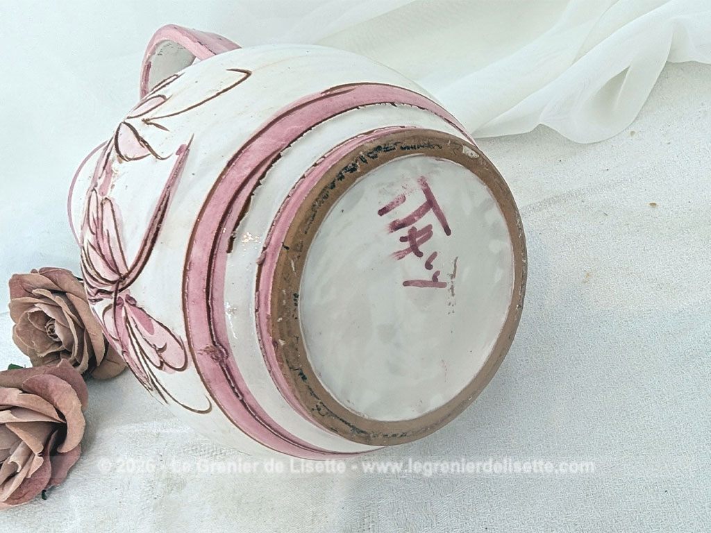 Sur 25 cm de haut, voici un joli vase pichet en terre cuite émaillée blanche décoré d'un superbe décor floral peint à la main dans de beaux tons rose poudré, souligné de fins contours brun clair tracés à la main. Signé et Made in Italy.