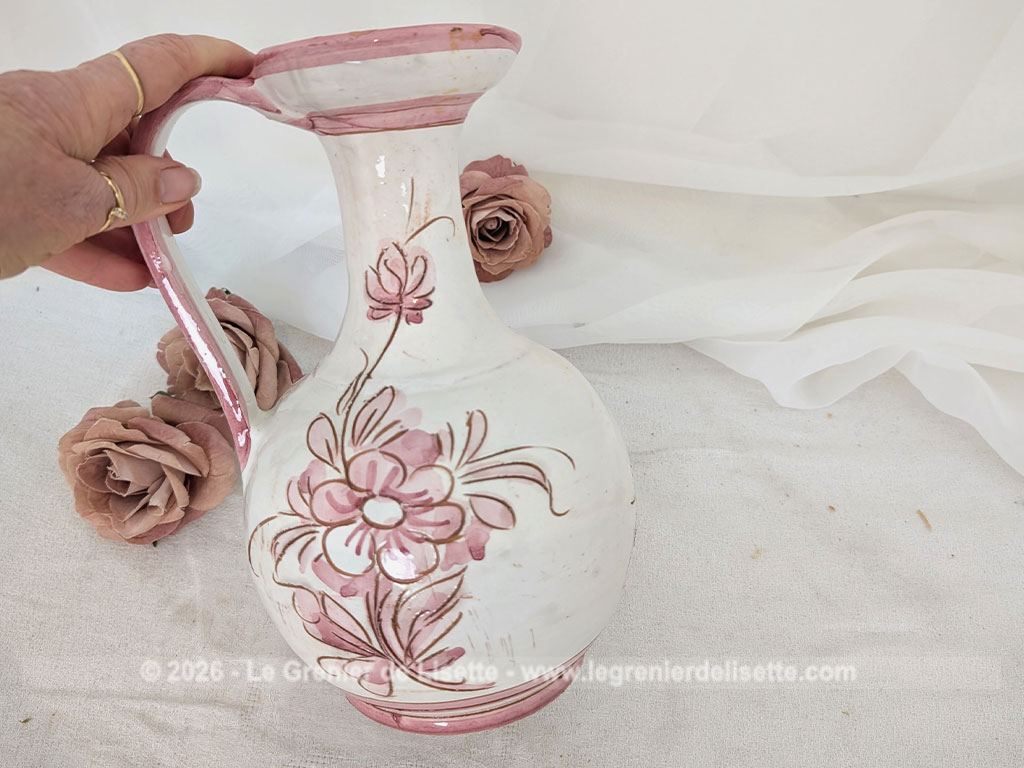 Sur 25 cm de haut, voici un joli vase pichet en terre cuite émaillée blanche décoré d'un superbe décor floral peint à la main dans de beaux tons rose poudré, souligné de fins contours brun clair tracés à la main. Signé et Made in Italy.