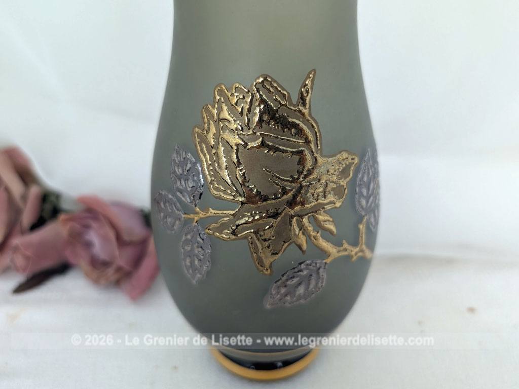 Sur 21 cm de haut, voici un très élégant vase en verre fumé dépoli au charme vintage, décoré d'une délicate rose en relief rehaussée de dorure et d'argenture, et de liserés dorés au col et à la base.